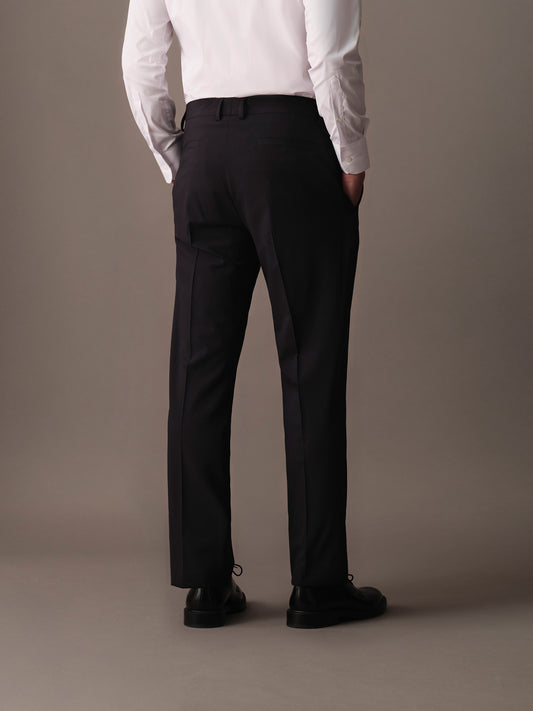 Rear view of refined men’s trousers with welt pockets and clean cutting