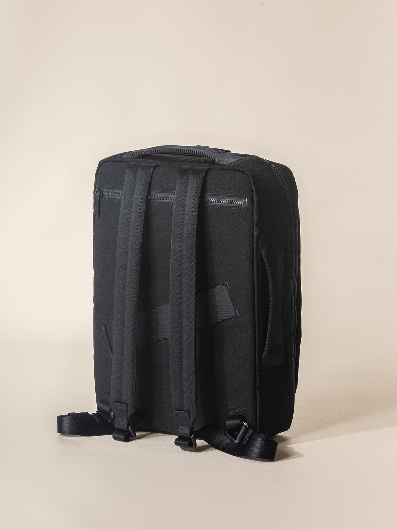 A professional-looking black business backpack with multiple compartments and a top handle for easy carrying.