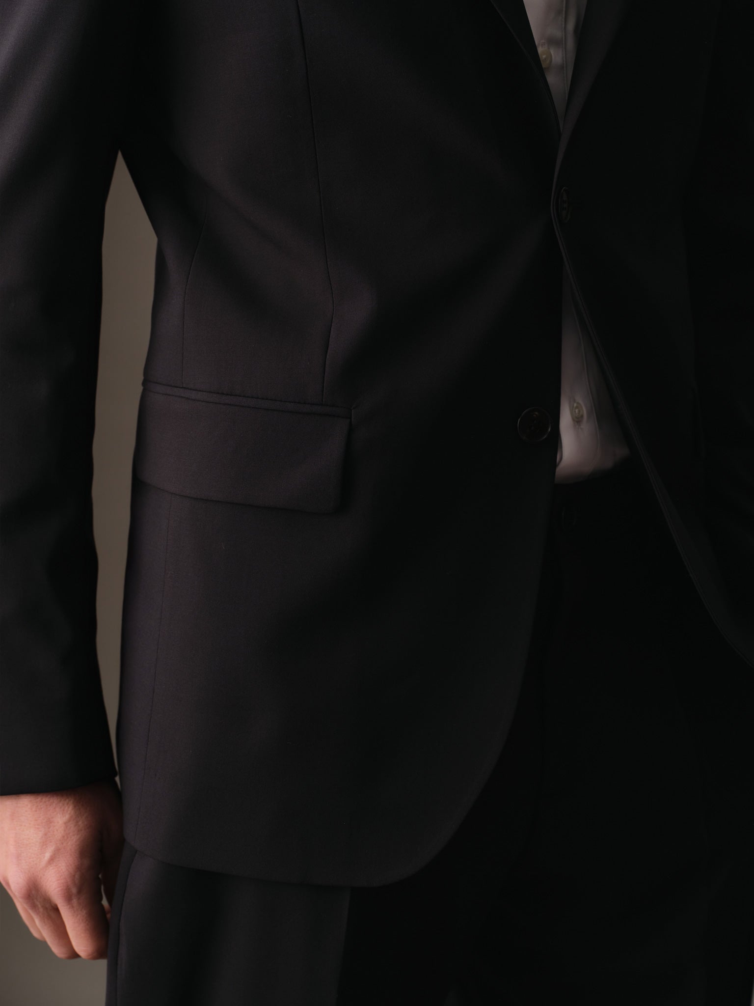 Lower flap pocket and sleeve button detail on refined wool blazer