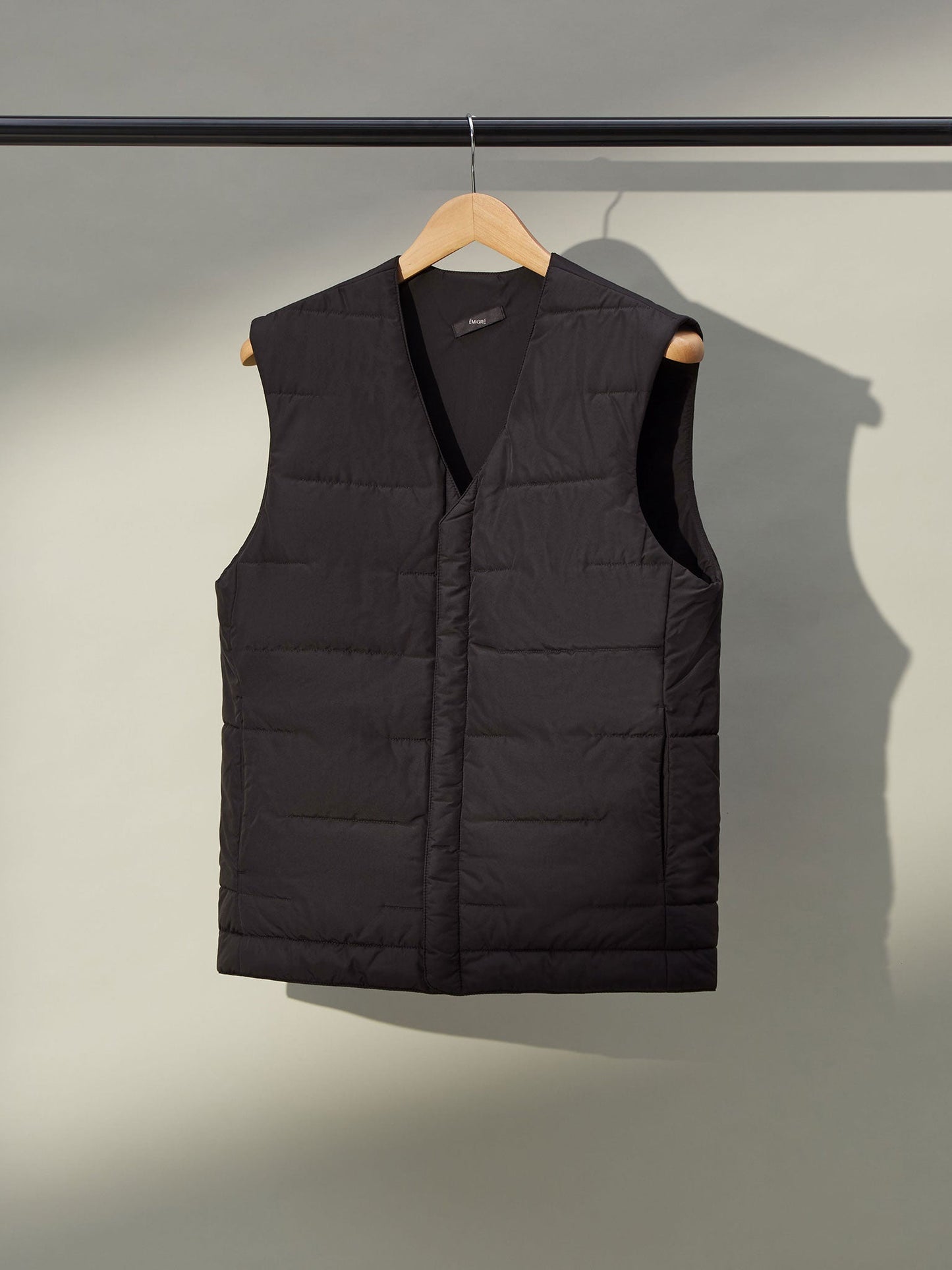 A close-up of a men's grey gilet with a front zipper and two pockets.