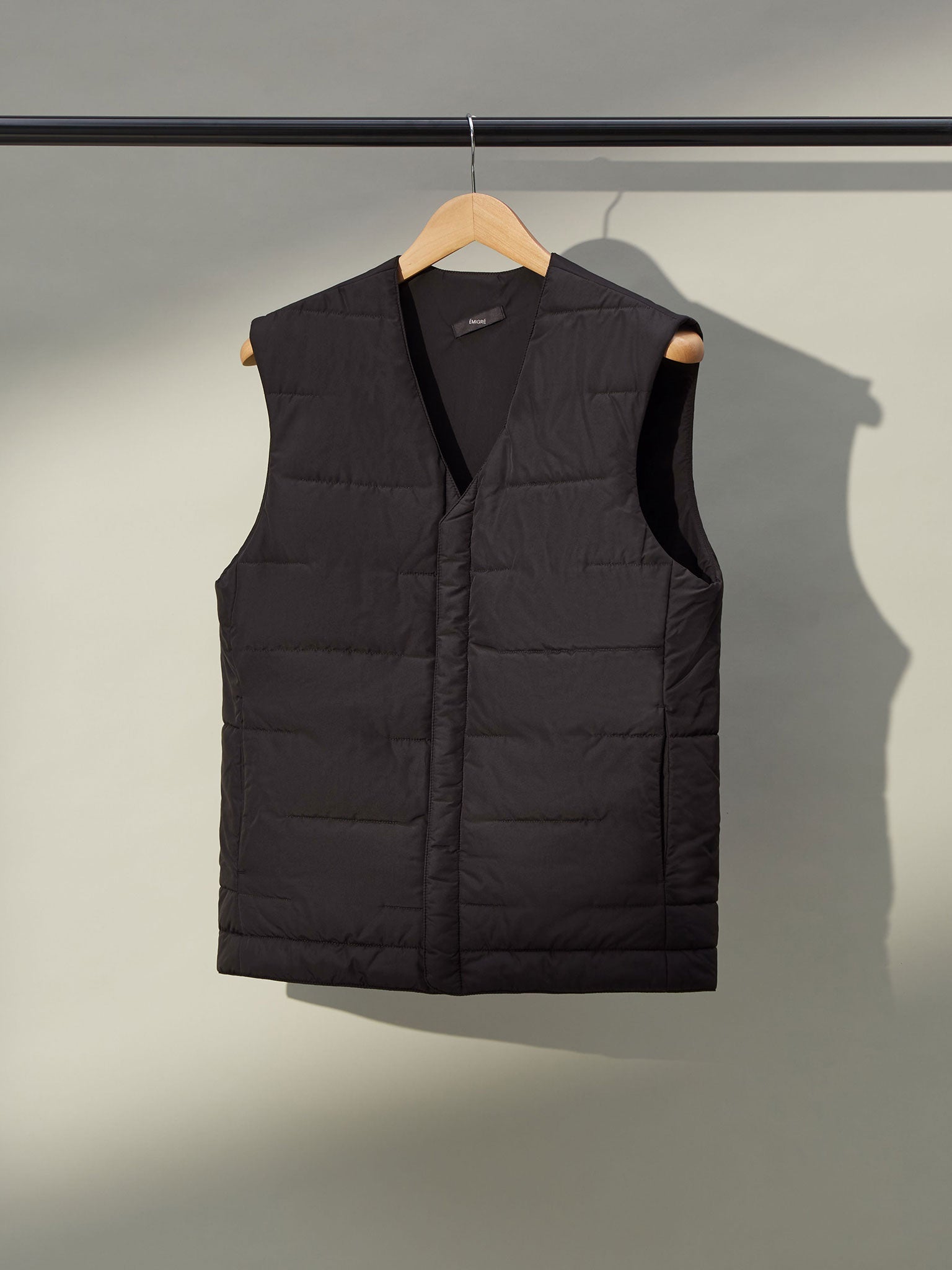 A close-up of a men's grey gilet with a front zipper and two pockets.