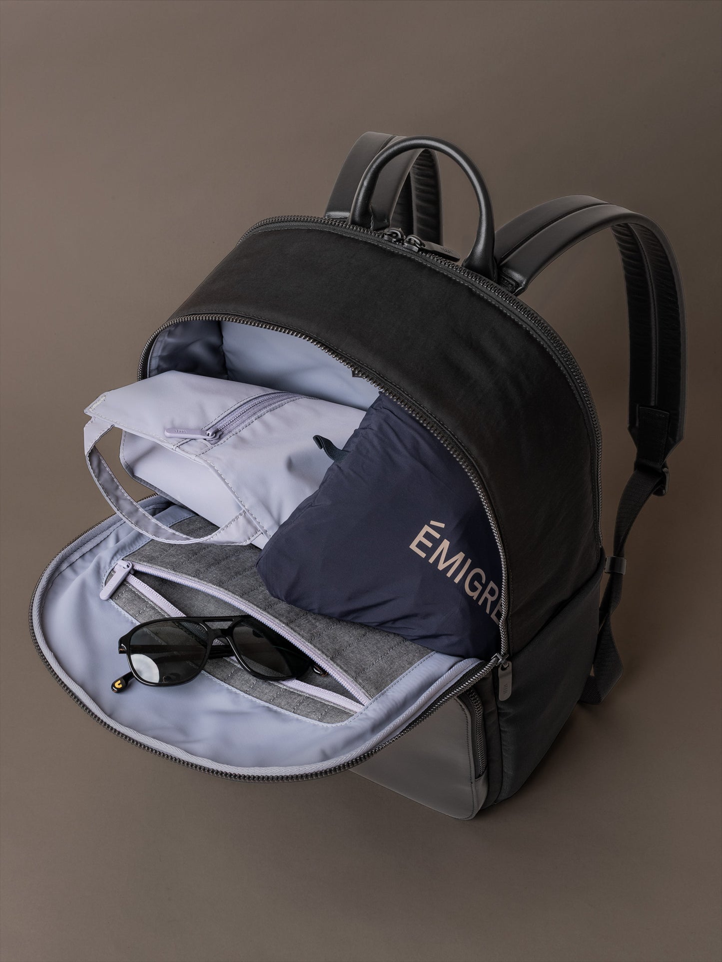 Open main compartment of The Boardroom Backpack showing travel pouch and sunglasses storage