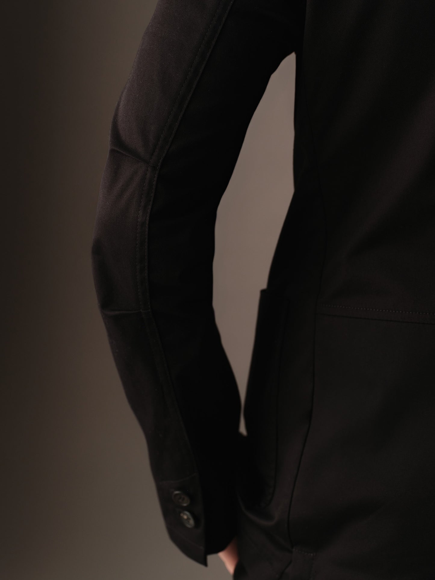 Side view of sleeve and articulated elbow detailing on the men’s cotton blazer