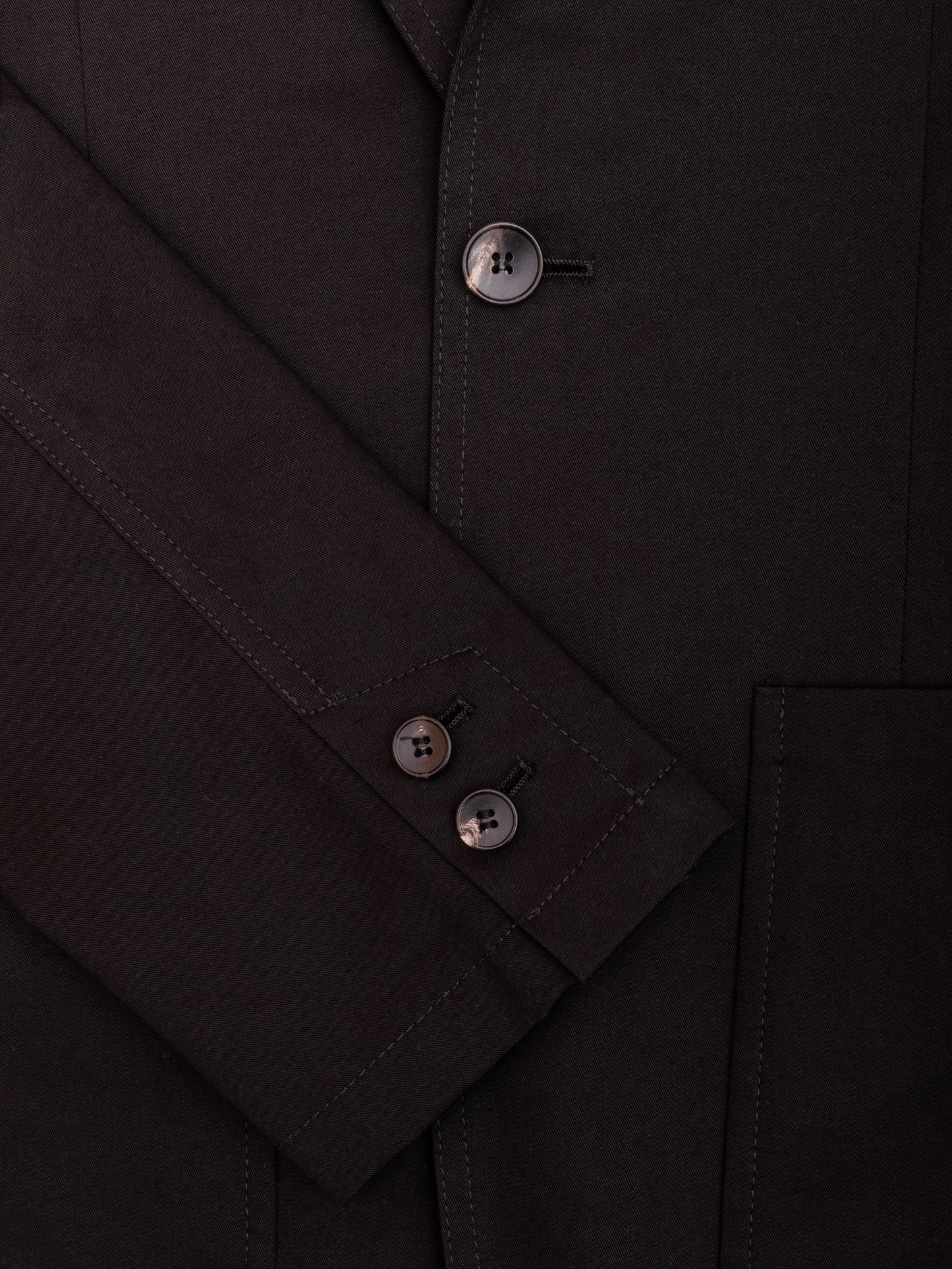 Close-up of sleeve buttons and textured fabric on the men’s cotton blazer