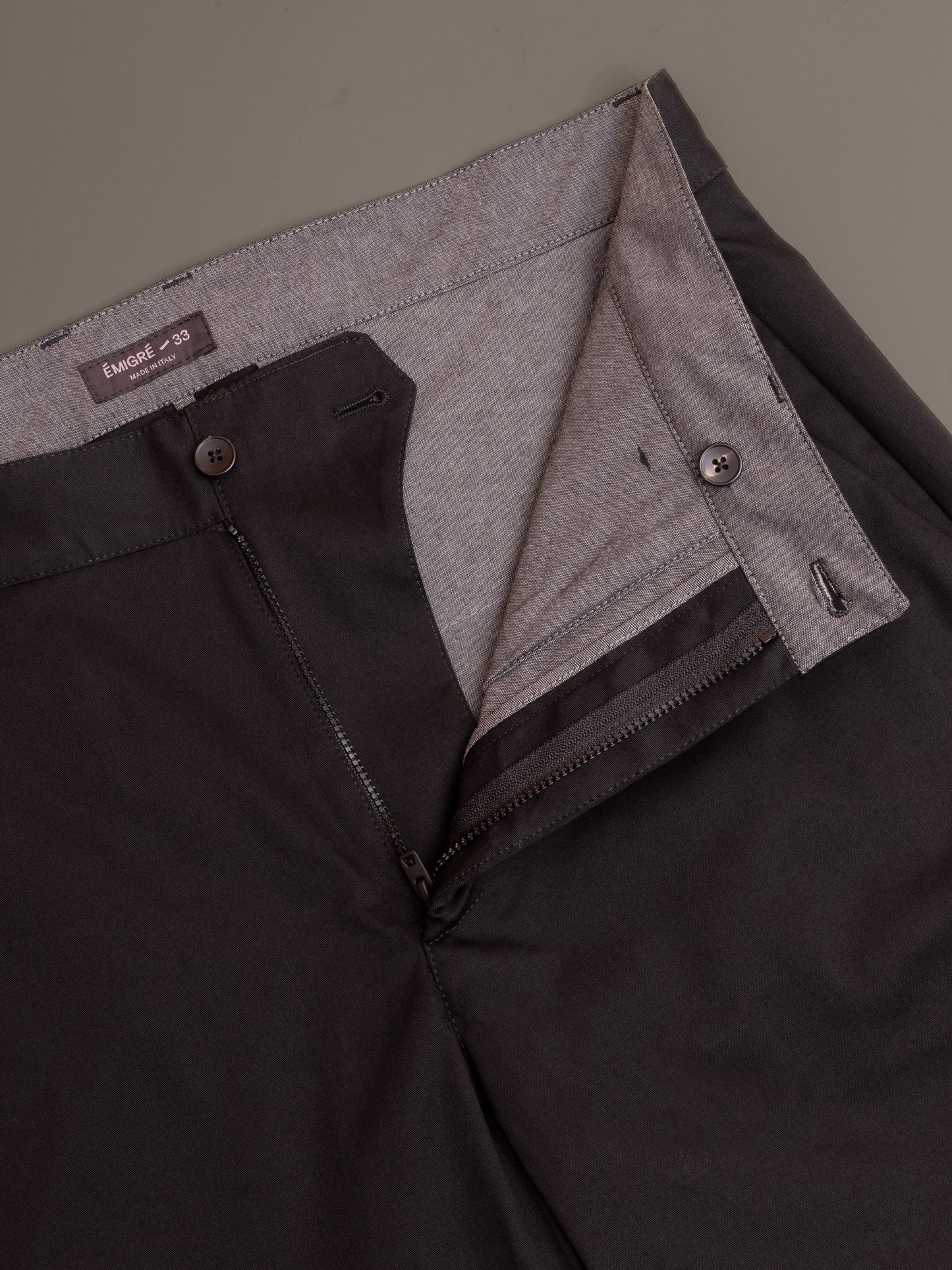 Flat lay view of cotton trousers for men showing waistband fly and interior details