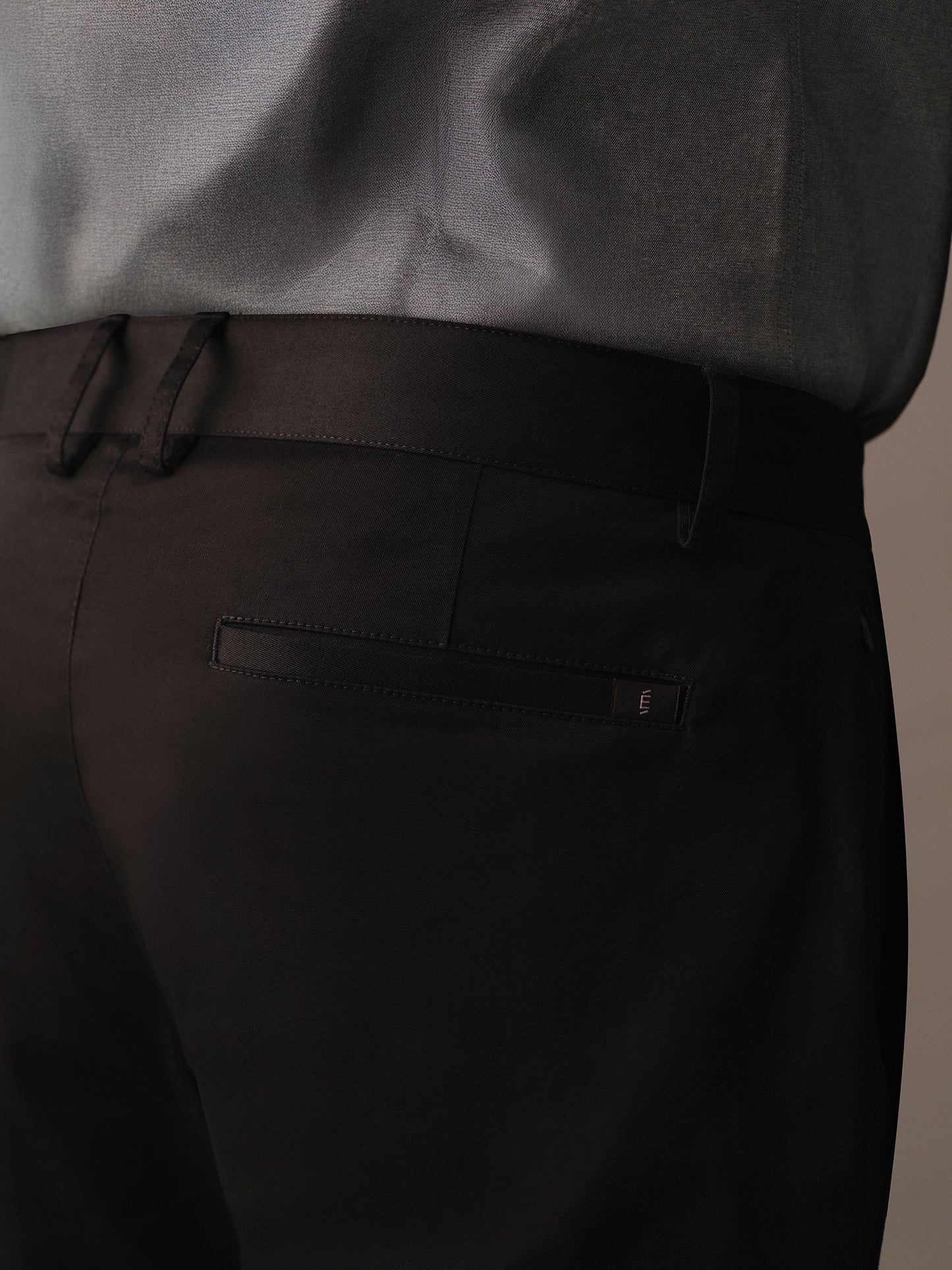Back welt pocket detail on black cotton trousers for men
