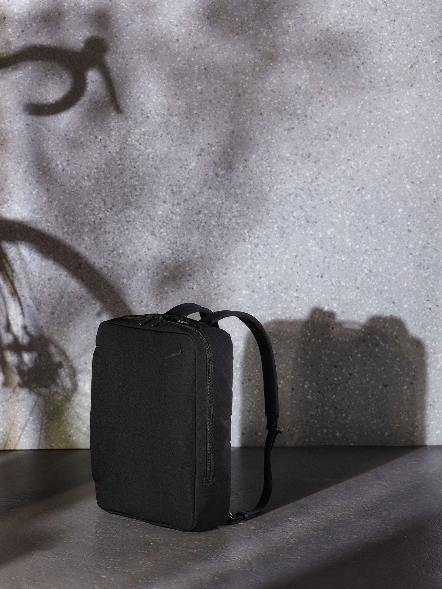 A versatile black backpack for travel, featuring a waterproof exterior and spacious compartments for clothes, electronics, and other travel essentials.