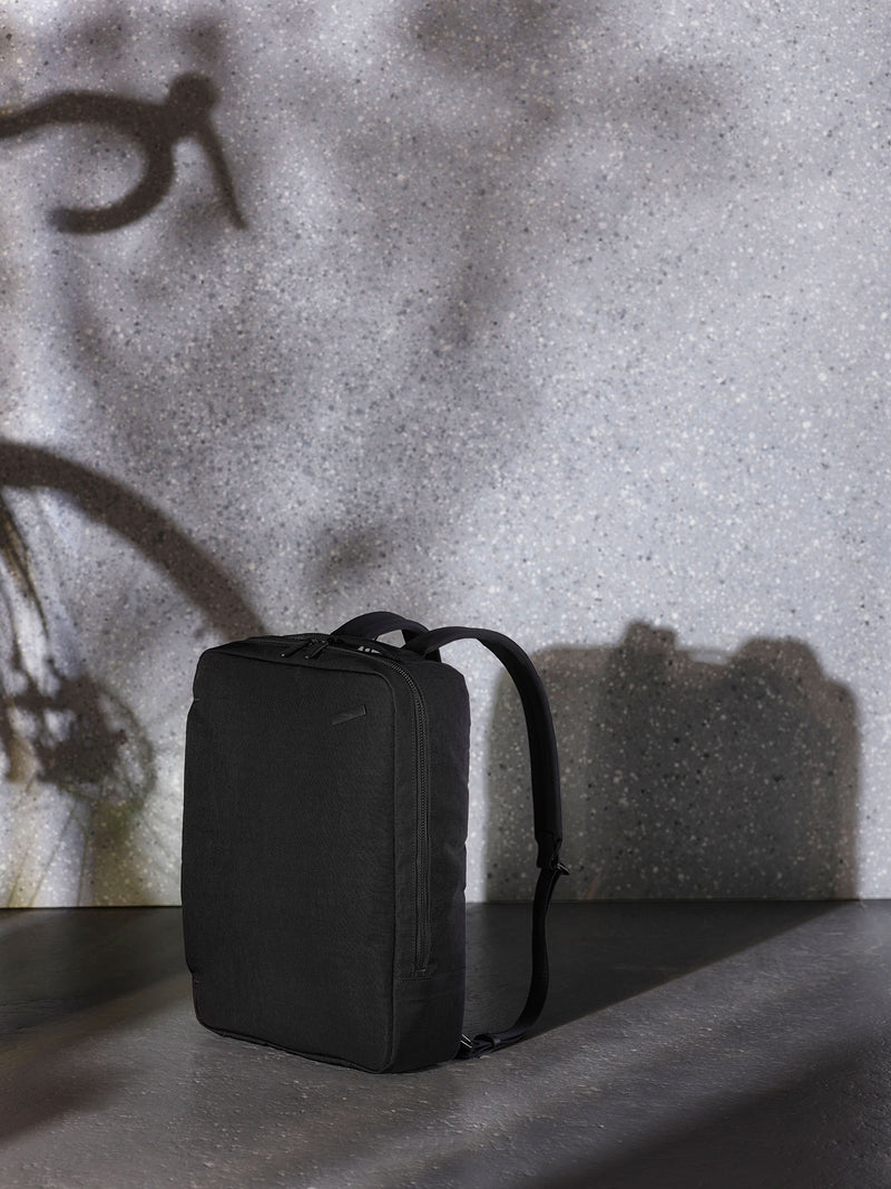 A versatile black backpack for travel, featuring a waterproof exterior and spacious compartments for clothes, electronics, and other travel essentials.