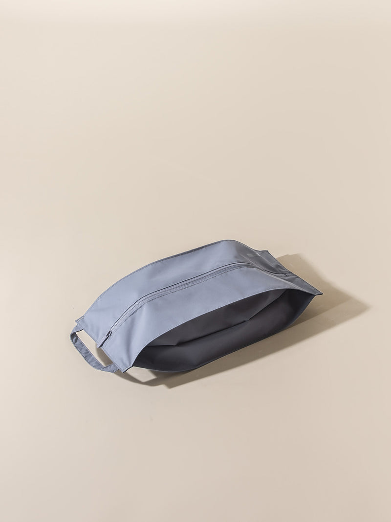 Lightweight and water resistant, the Émigré Shoe Bag doubles as a compact laundry bag.